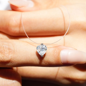 Macro shot of heart-shaped moissanite pendant on a transparent fishing line necklace