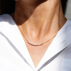 925 silver 1ct moissanite smile necklace in gold finish worn on white shirt model
