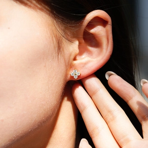 Exquisite 18K rose gold four-leaf clover moissanite earrings worn on a female ear