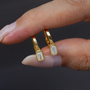 Macro shot of 14K gold plated silver earrings with emerald-cut rectangle moissanite stone
