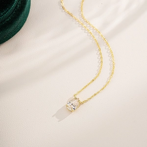 18K gold teardrop pear cut clear stone pendant necklace on elegant jewelry box display