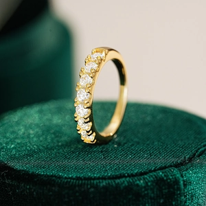 Macro shot of gold-plated silver ring with rows of sparkling stones on velvet