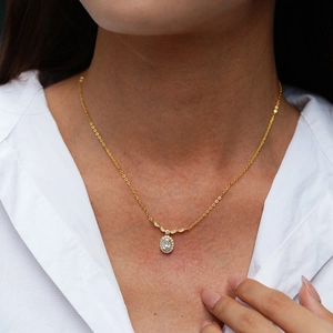 Elegant S925 sterling silver necklace featuring a gold oval halo moissanite pendant on a model