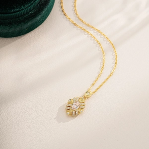 Close-up of vintage gold necklace with oval champagne stone and intricate metalwork