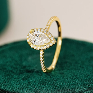 Macro d'une bague moissanite 1ct taille poire avec halo sur support velours vert