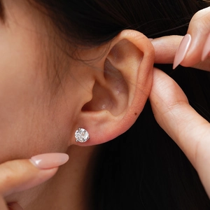 Minimalist S925 sterling silver three-prong moissanite stud earring on a female ear