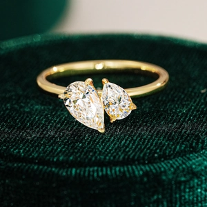 Moissanite Toi et Moi ring with pear-cut stones in gold plating on green velvet