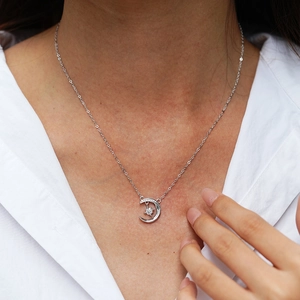 S925 sterling silver moon and star necklace with moissanite pavé on a model