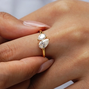 Golden 925 sterling silver Toi et Moi ring featuring two pear-cut moissanite stones