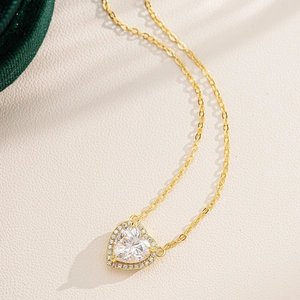 Macro shot of 925 silver heart pendant necklace with gold plating and sparkling zircon