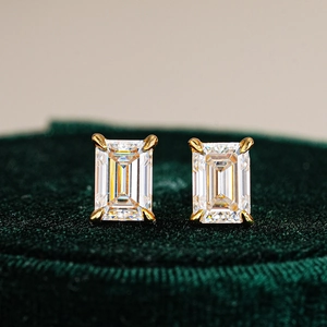 Elegant emerald cut moissanite stud earrings in 925 silver on green velvet padding