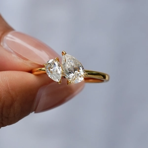 Classic Toi et Moi 18K gold ring with double pear-cut moissanite stones on finger