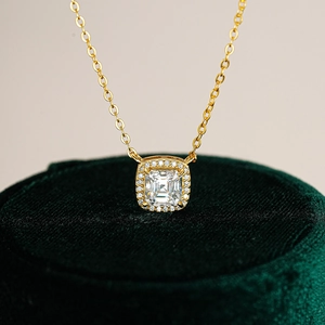 Square cut moissanite pendant necklace in gold finish on green velvet display