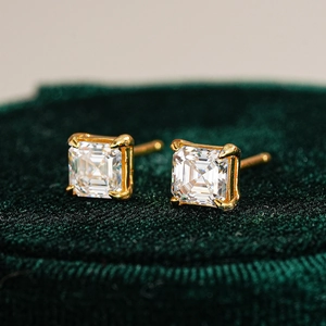 Macro shot of square cut moissanite earrings in 18K gold plated four-claw settings