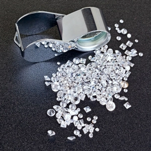 Sparkling moissanite loose stones in various cuts with a professional jewelry loupe