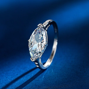 Macro shot of marquise cut moissanite ring with six-prong setting and side diamonds