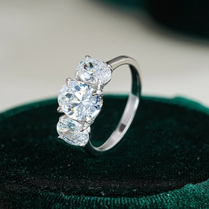 Three-stone S925 sterling silver ring with oval-cut moissanite gems on a velvet stand