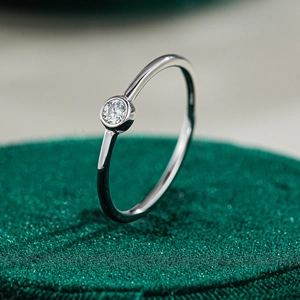 Macro shot of minimalist S925 sterling silver ring with round brilliant moissanite setting
