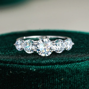 Macro di un anello in argento 925 con cinque moissaniti su una scatola di velluto verde
