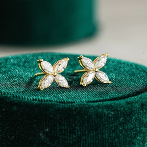 Macro shot of 925 silver gold-plated clover stud earrings with marquise-cut moissanite