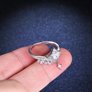 Classic silver ring with square zircon, side diamonds and star pendant on blue background
