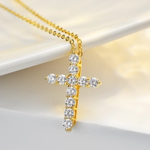 925 silver 1 carat moissanite cross pendant necklace with 14K gold plating on silk backdrop