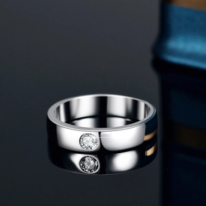 Polished S925 sterling silver moissanite ring with round cut stone on a reflective surface