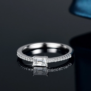 Elegant S925 silver ring with emerald-cut emerald and side diamonds on black surface
