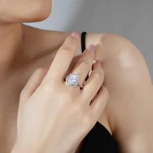 Elegantly crafted 2-carat pear shaped moissanite halo ring in silver on woman's finger