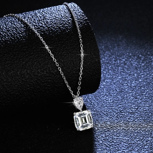 S925 silver necklace featuring pear and emerald cut moissanite pendants on a dark base