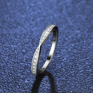 Crossed S925 silver ring with Moissanite pavé stones on a textured blue background