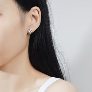 Elegant s925 silver four-leaf clover moissanite stud earrings worn by a model
