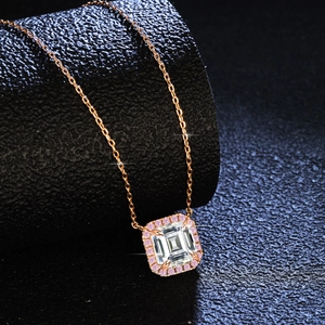 Emerald cut moissanite necklace in rose gold with pink halo on a black jewelry stand