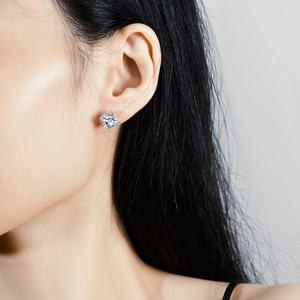 Square cut moissanite stud earring in 925 silver four-prong setting on model's ear