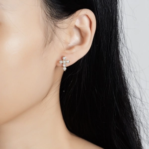 Elegant S925 sterling silver cross stud earrings with sparkling moissanite stones on model