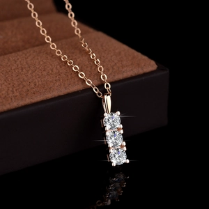 Three-stone moissanite pendant necklace in rose gold finish on a premium jewelry box