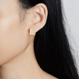 Square gold s925 silver stud earrings with pavé moissanite crystals worn by a model