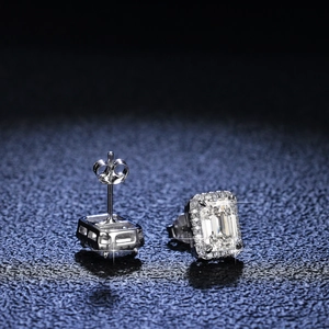 S925 sterling silver emerald cut moissanite halo stud earrings on textured surface
