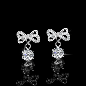 Elegant S925 silver bow earrings with round brilliant moissanite drops on black reflective surface