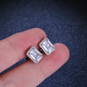 S925 sterling silver emerald cut moissanite halo stud earrings held in hand