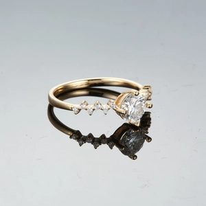 Champagne gold moissanite ring with six-prong setting and side diamond accents