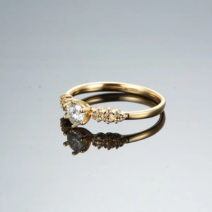 Gros plan d'une bague en moissanite or champagne avec une monture filigrane à six griffes