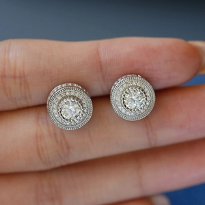 Gros plan de boucles d'oreilles moissanite en argent 925 avec design milgrain et halo