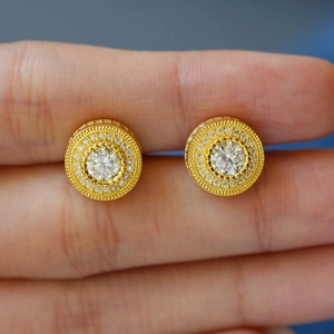 Boucles d'oreilles clous en moissanite argent 925 avec halo doré tenues à la main