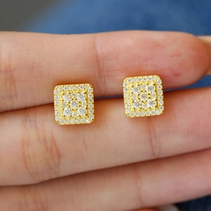 Macro shot of 925 silver square halo moissanite studs held to show scale and sparkle