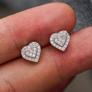 Macro detail of 925 sterling silver heart stud earrings with sparkling pave moissanite