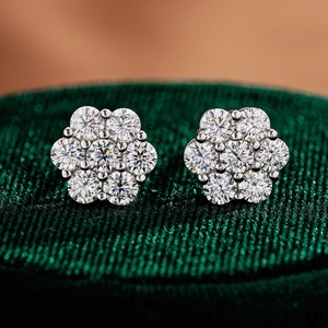 Macro shot of cluster moissanite stud earrings in a luxury green velvet jewelry box