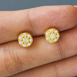 Macro shot of gold halo moissanite stud earrings featuring shimmering round cluster stones