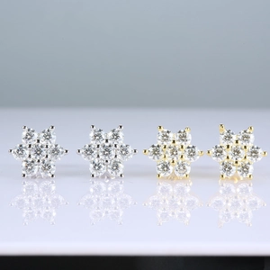Detailed view of 925 sterling silver snowflake moissanite stud earrings in silver and gold