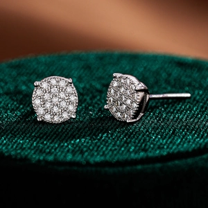Macro shot of 925 sterling silver moissanite stud earrings on a green velvet stand